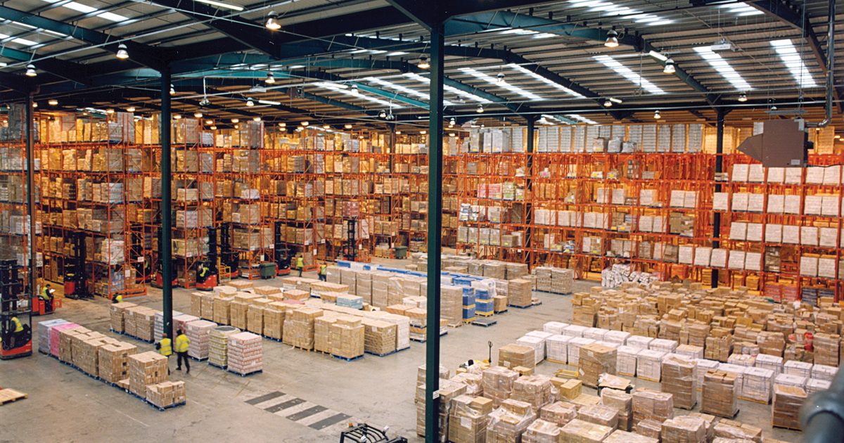 Interior de un almacen moderno con pallets y cajas en estanterias