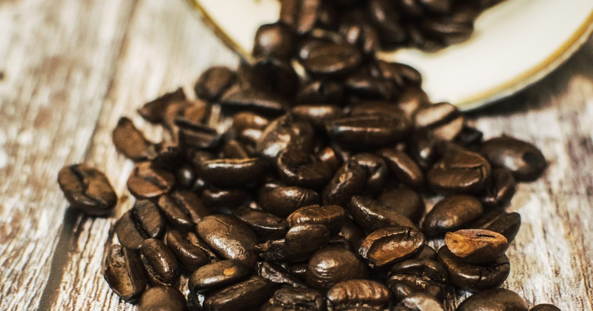 Granos de cafe derramados de un envase, representando la merma