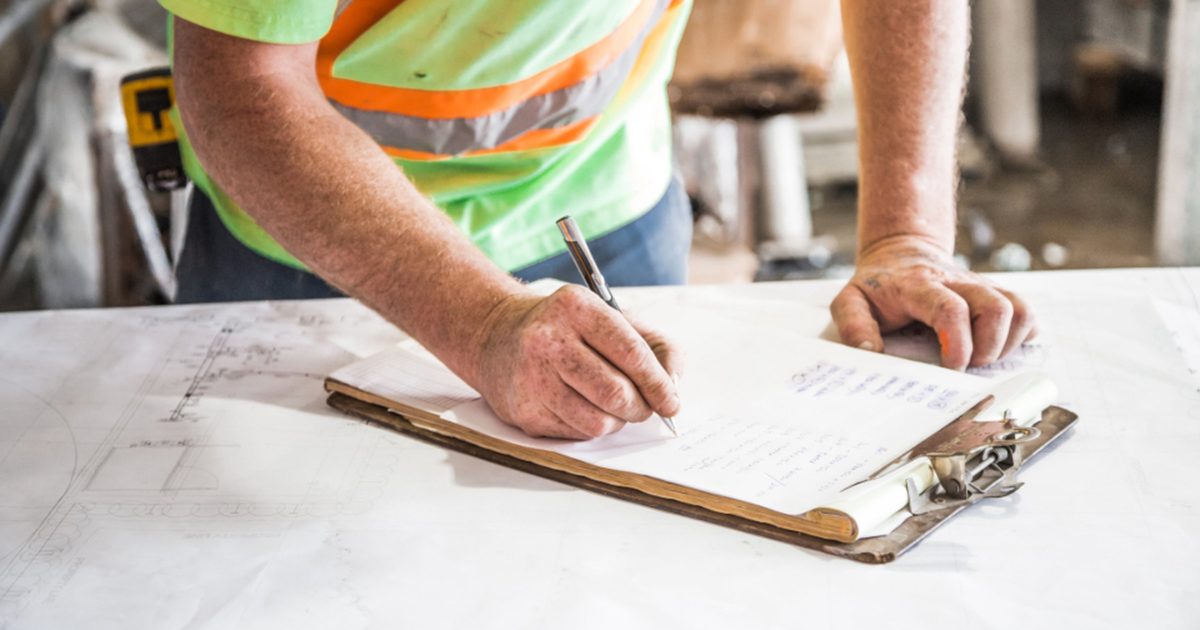 Persona registrando datos en una planilla sujeta a un portapapeles